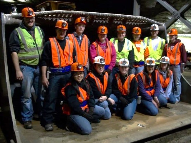 A mining engineering crew underground in hi-vis gear and hardhats